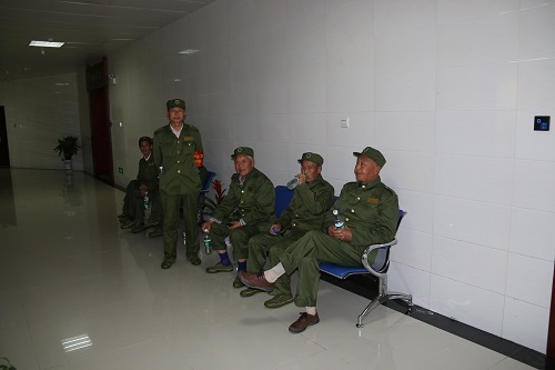 参观的老人们坐在展厅通道内的座椅上喝水、休息